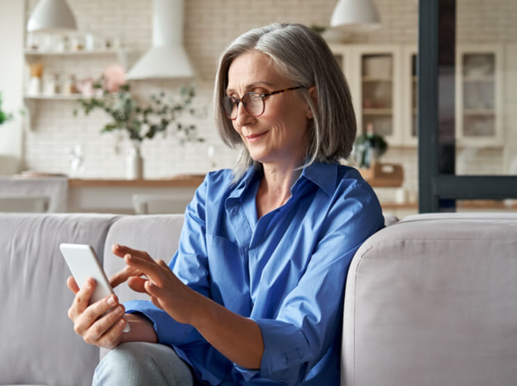 older middle aged female customer holding smartphone using mobile