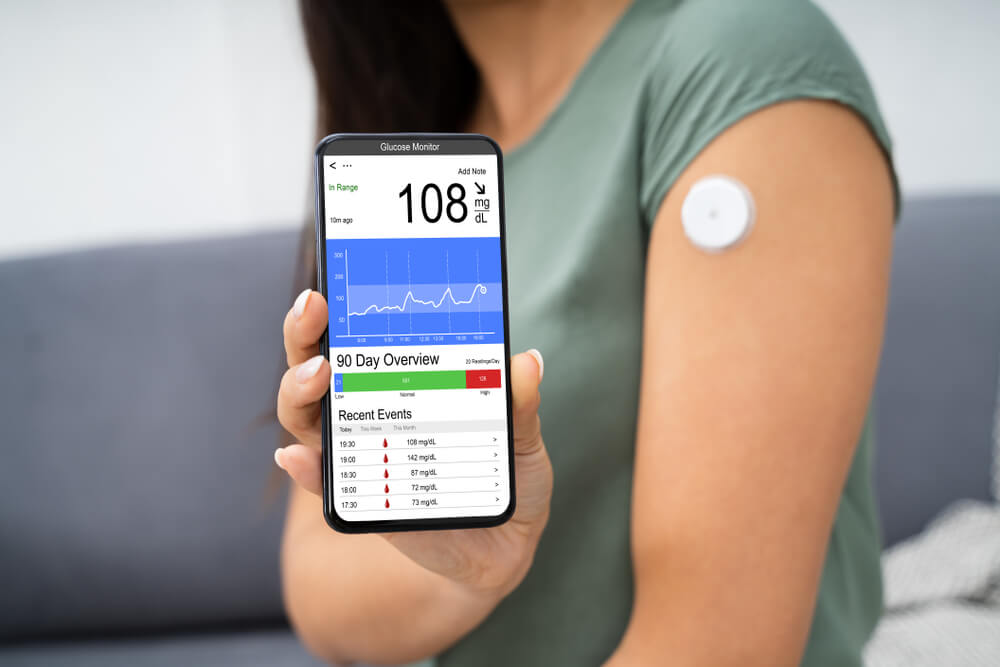 Woman Holding Smartphone In Hand With Bad Level Of Blood Sugar On The Screen