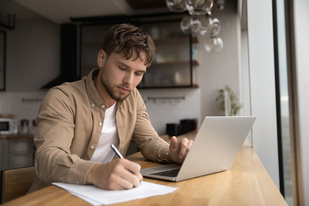 Man on a laptop writing notes, tracking his biochemistry
